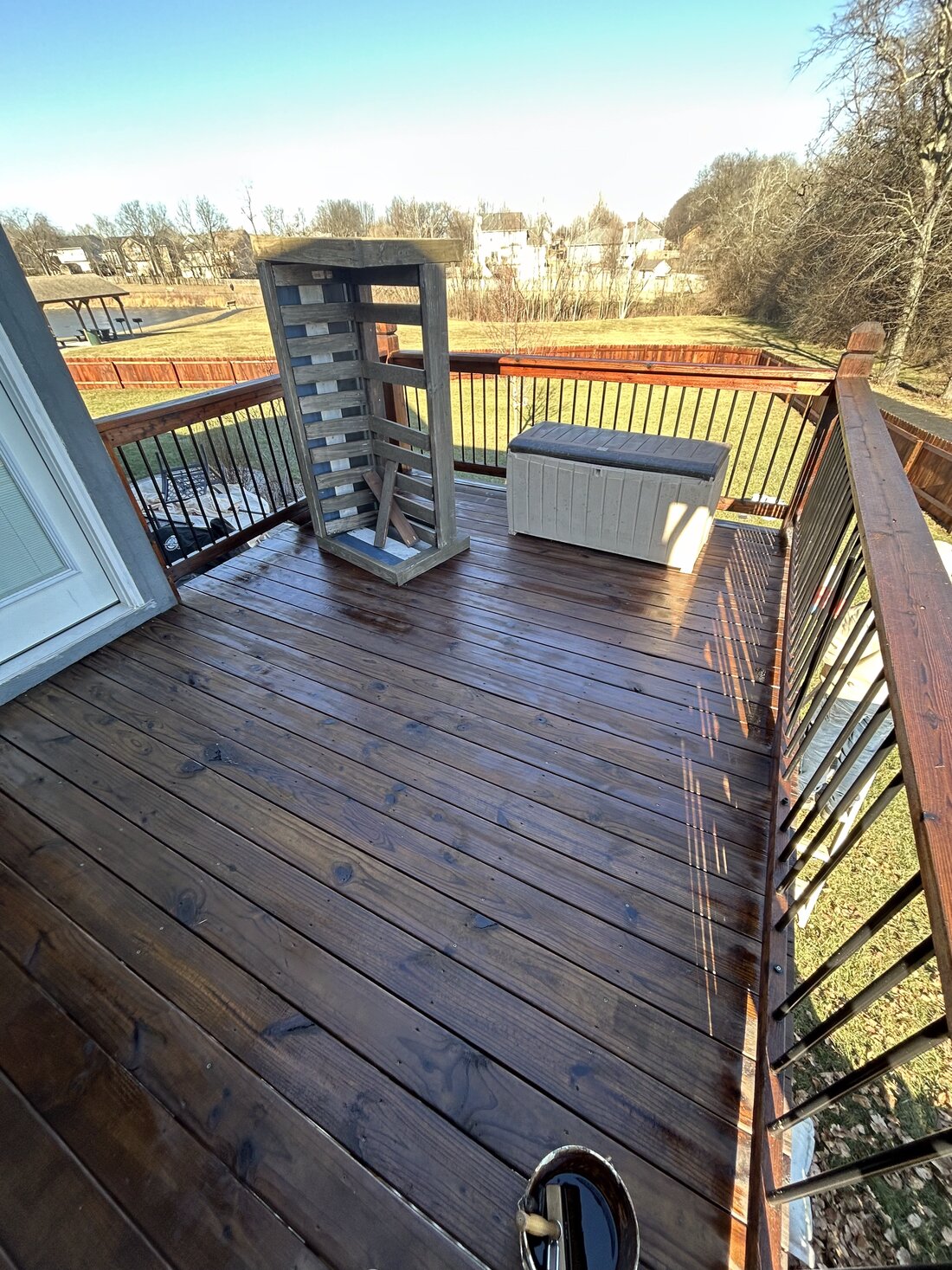 Freshly stained wood deck overlooking a greenbelt